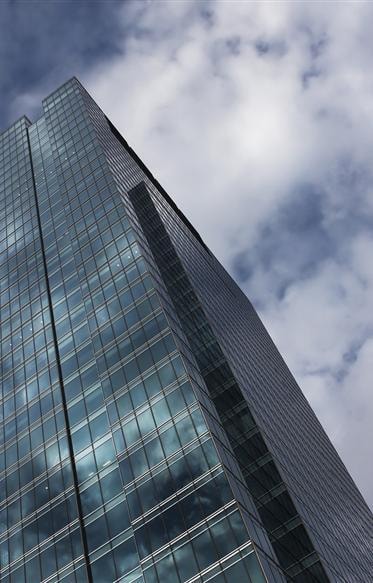 Modern glass skyscraper against a cloudy sky