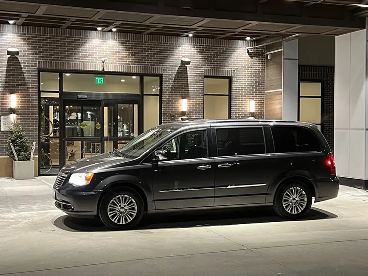 A black van parked in front of a building.