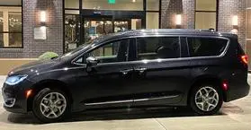 A black van parked in front of a building.