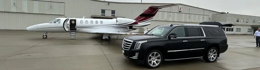 A private jet parked next to a black car.